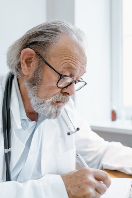 Doctor wearing stethoscope writing on a clipboard, close-up — বয়স্কদের মাথা ঘোরা | Dr. Prateek Porwal, ENT
