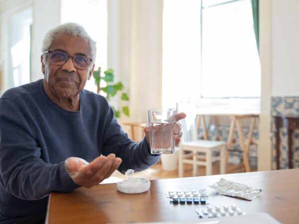 Elderly man holding pills and glass of water — ચક્કર આવતું હોય તો શું ખાવું | Dr. Prateek Porwal, ENT