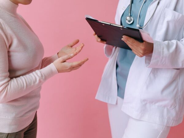 Doctor with patient discussing medical issue, holding clipboard — ચક્કર આવવાના 7 મુખ્ય કારણો | Dr. Prateek Porwal, ENT