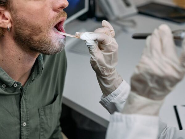 Doctor examining patient's throat with a tongue depressor — चक्कर आले तर डॉक्टरांना कधी भेटावे | Dr. Prateek Porwal, ENT