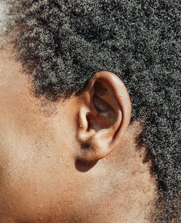 Close-up profile of a human ear with dark curly hair — gaze stabilization exercises for vertigo | Dr. Prateek Porwal, ENT