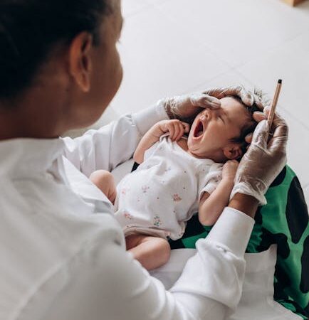 Doctor examining a yawning baby's ear with a pen — labyrinthitis in children | Dr. Prateek Porwal, ENT