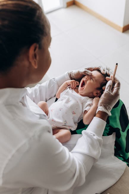 Doctor examining a yawning baby's ear with a pen — labyrinthitis in children | Dr. Prateek Porwal, ENT