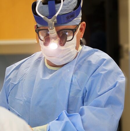 Surgeon wearing loupes and headlamp during a medical procedure — otosclerosis treatment | Dr. Prateek Porwal, ENT