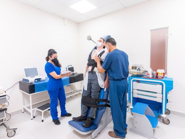 Patient in chair with medical equipment, staff observing — સમતુલા કસરતો | Dr. Prateek Porwal, ENT