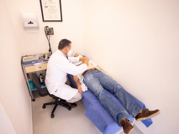 Doctor examines patient lying on examination table with stethoscope — शुगर और BP से चक्कर | Dr. Prateek Porwal, ENT