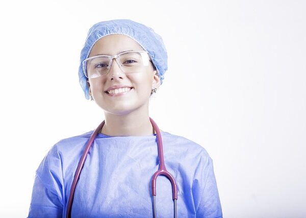 Smiling doctor in surgical attire with stethoscope and glasses — Vertigo Specialist Hyderabad | Dr. Prateek Porwal, ENT