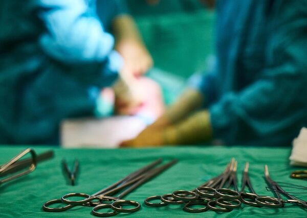 Surgical instruments on a green cloth with blurred surgeons in background — Vertigo Doctor in Ghaz… | Dr. Prateek Porwal, ENT