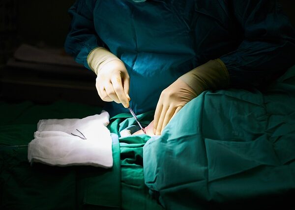 Surgeon's hands performing a medical procedure with surgical instruments — Vertigo Doctor in Unnao | Dr. Prateek Porwal, ENT