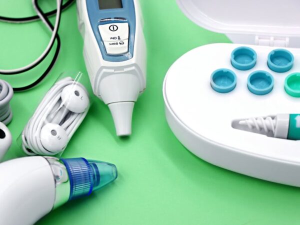 Medical thermometer, ear swabs, and nasal aspirator on green background — Vertigo in Women Over | Dr. Prateek Porwal, ENT