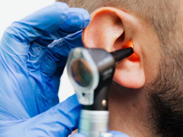 Doctor examining ear canal with otoscope and blue gloves — vestibular rehabilitation after neuritis | Dr. Prateek Porwal, ENT