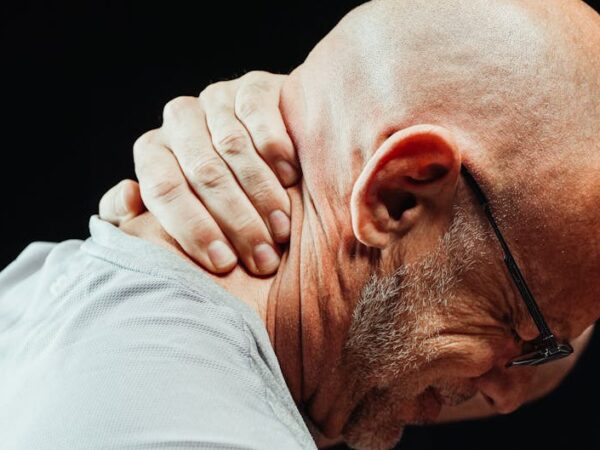 Man holding his neck, showing pain or discomfort — बुजुर्गों में चक्कर | Dr. Prateek Porwal, ENT