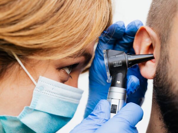Doctor examining patient's ear with an otoscope — What Causes BPPV | Dr. Prateek Porwal, ENT